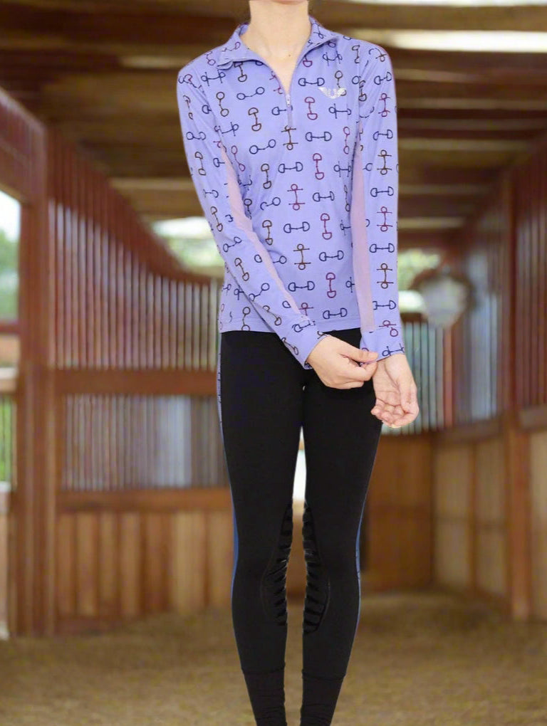 Person wearing a purple patterned shirt and black leggings on a white background