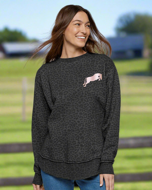 Woman wearing a dark gray sweatshirt with a pink graphic on a light gray background