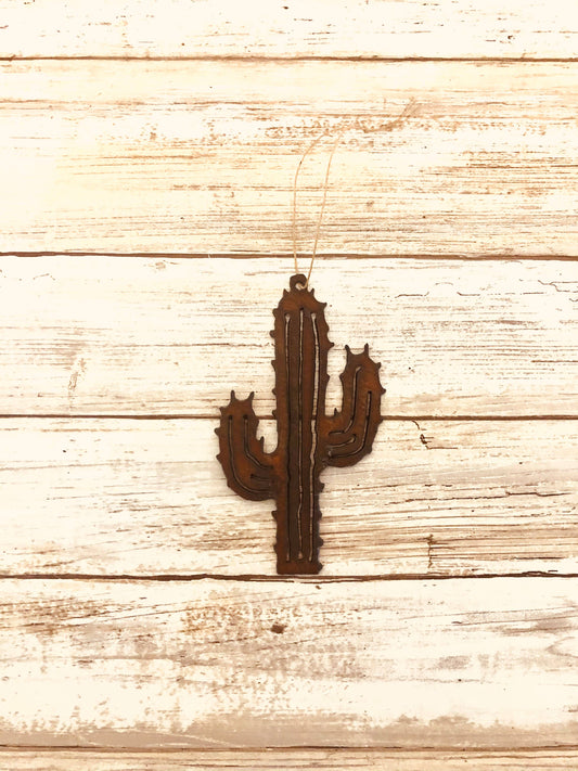 A brown metal cactus-shaped ornament on a wooden background.